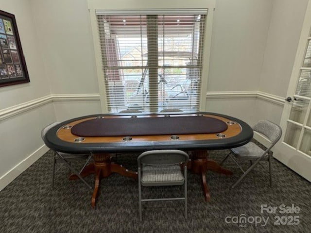 carpeted dining space featuring baseboards