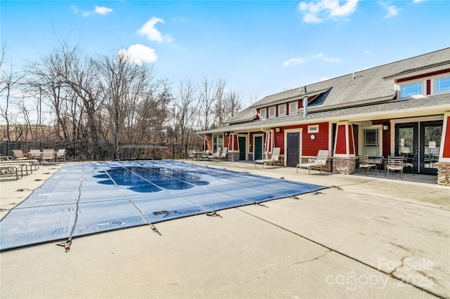 pool with a patio area and fence