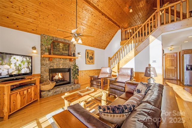 living area featuring hardwood / wood-style floors, a ceiling fan, wooden ceiling, and wainscoting