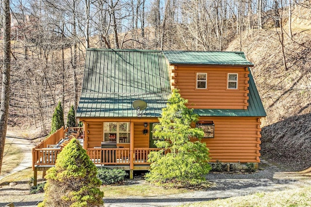 log cabin featuring metal roof and log exterior