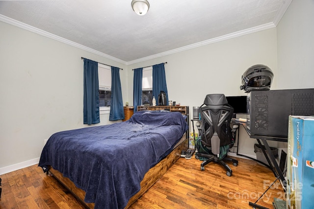 bedroom featuring crown molding, wood finished floors, and baseboards