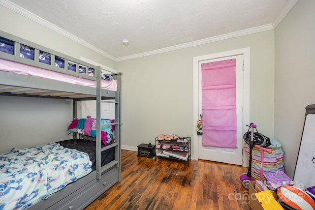 bedroom with ornamental molding, a textured ceiling, and wood finished floors