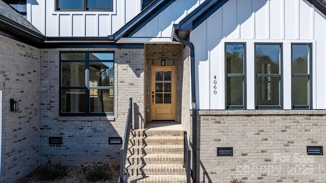 doorway to property with brick siding and board and batten siding