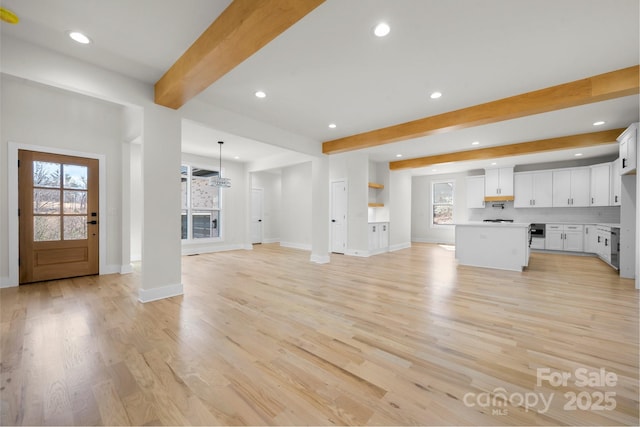 interior space featuring beamed ceiling, recessed lighting, baseboards, and light wood-style floors