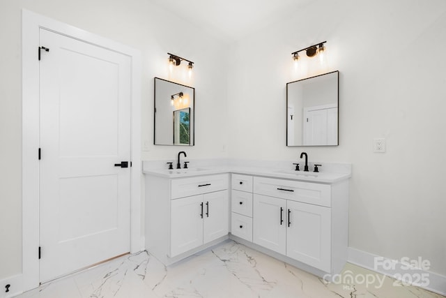 bathroom with double vanity, baseboards, marble finish floor, and a sink