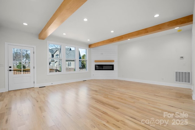 unfurnished living room with beam ceiling, baseboards, visible vents, and light wood-type flooring