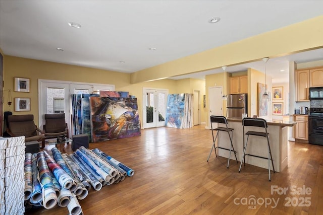 living room with light wood-type flooring, french doors, and recessed lighting