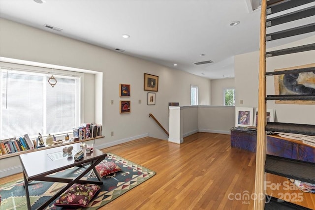 living room with recessed lighting, visible vents, light wood-style flooring, and baseboards