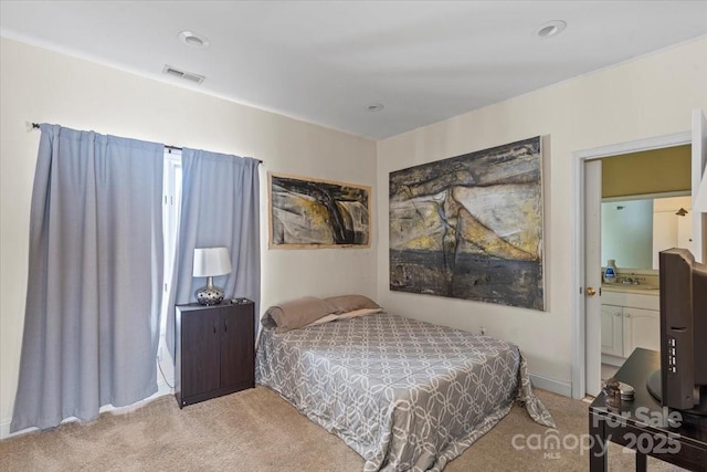 carpeted bedroom with a sink and visible vents