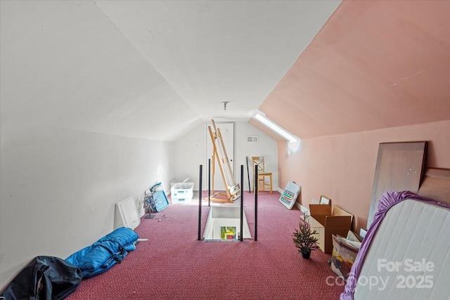 interior space with visible vents, carpet flooring, and vaulted ceiling