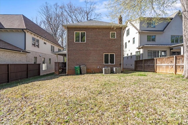 rear view of property with brick siding, central air condition unit, and fence