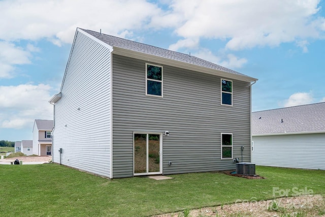 rear view of property with a yard and central AC unit