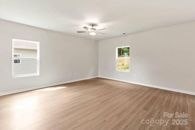 empty room with light wood-type flooring, baseboards, visible vents, and ceiling fan