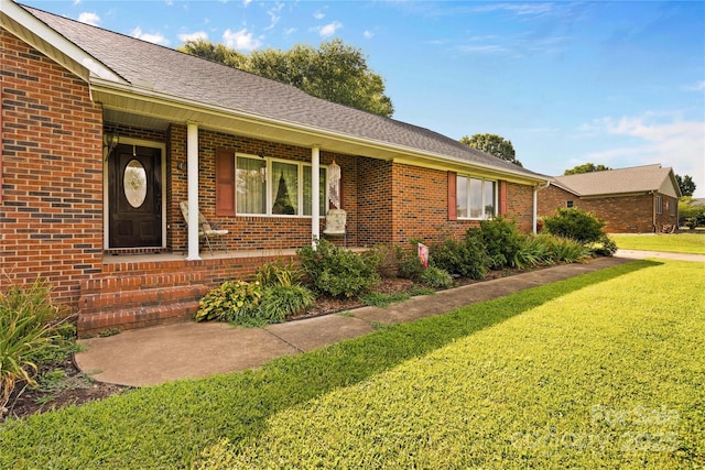 ranch-style house featuring a front lawn, brick siding, and a shingled roof