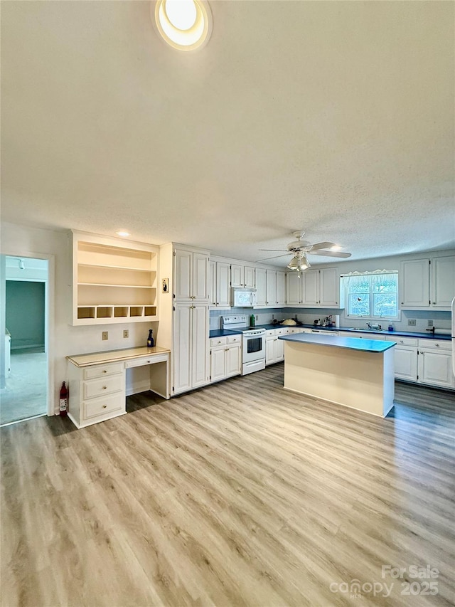 kitchen featuring white appliances, light wood-style flooring, a ceiling fan, and open shelves