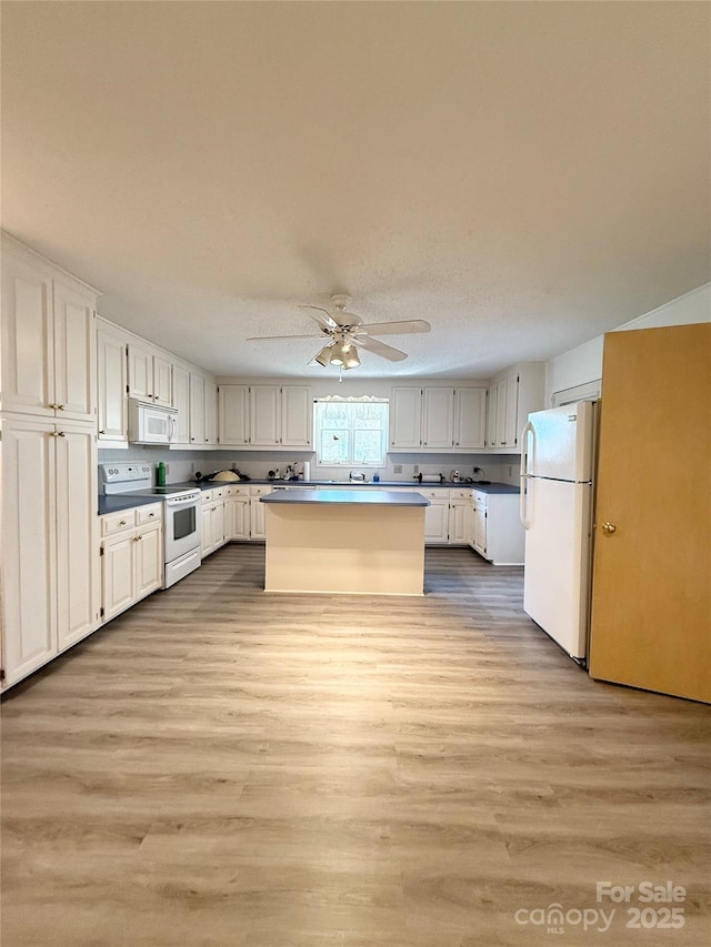 kitchen with white cabinetry, white appliances, light wood-style flooring, and a center island