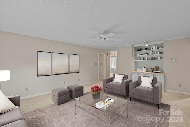 living room featuring ceiling fan, light carpet, baseboards, and a textured ceiling