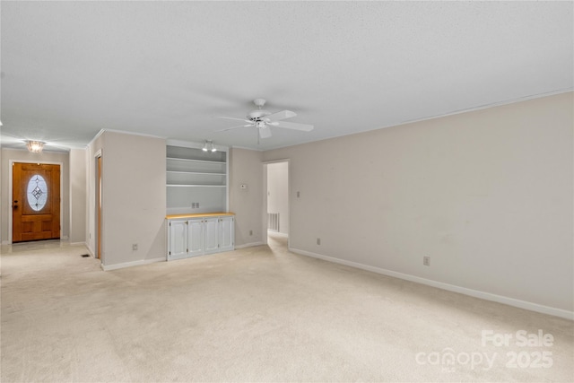 unfurnished living room with baseboards, light carpet, a textured ceiling, and a ceiling fan