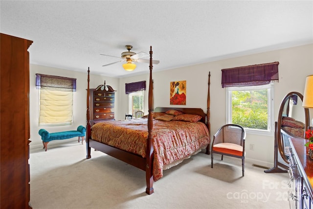 carpeted bedroom with baseboards, a textured ceiling, and a ceiling fan