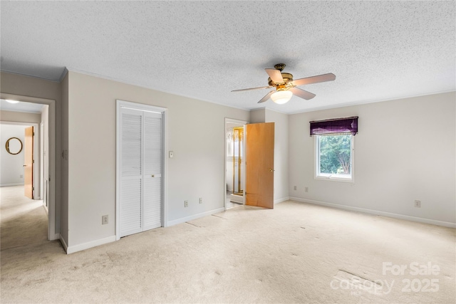 unfurnished bedroom featuring ceiling fan, carpet flooring, baseboards, and a textured ceiling