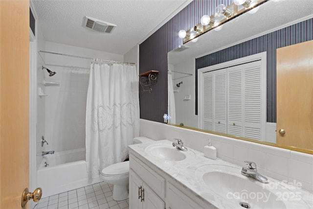 full bath with a sink, visible vents, a textured ceiling, and toilet