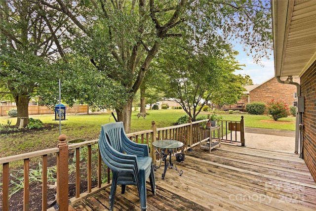 wooden terrace featuring a lawn