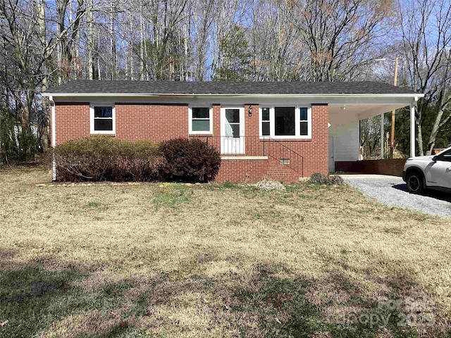 ranch-style house featuring a front yard, brick siding, and driveway