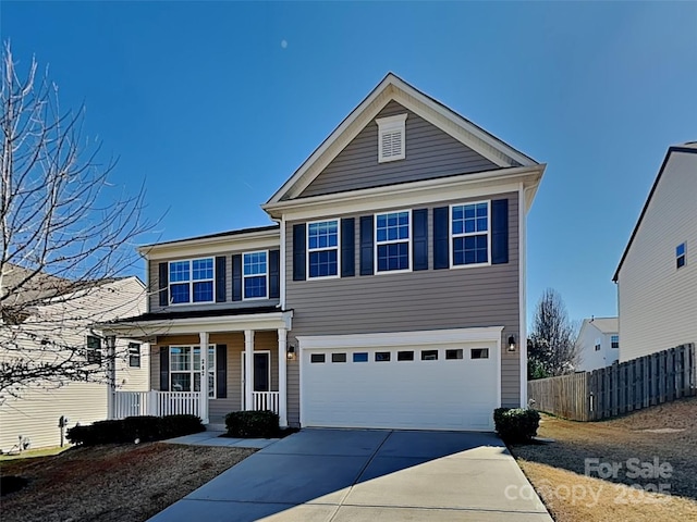 traditional-style house featuring a garage, covered porch, driveway, and fence