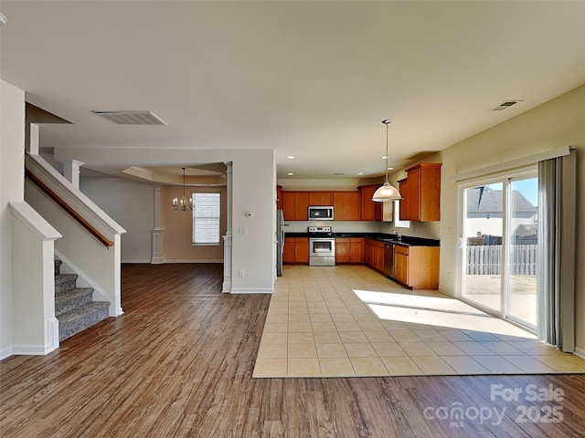 kitchen with dark countertops, visible vents, stainless steel appliances, and open floor plan