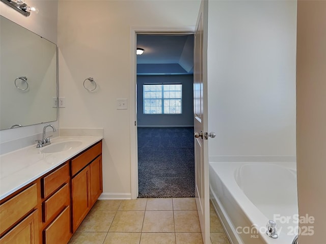 bathroom featuring tile patterned flooring, vanity, and a tub to relax in