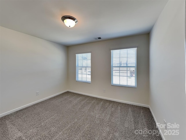 spare room with visible vents, baseboards, and carpet