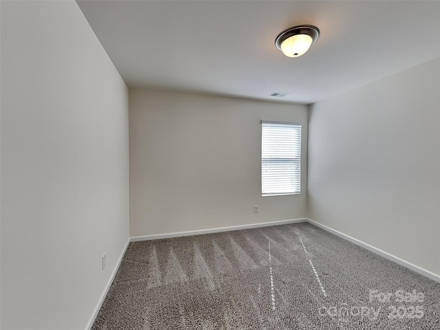 carpeted spare room with visible vents and baseboards