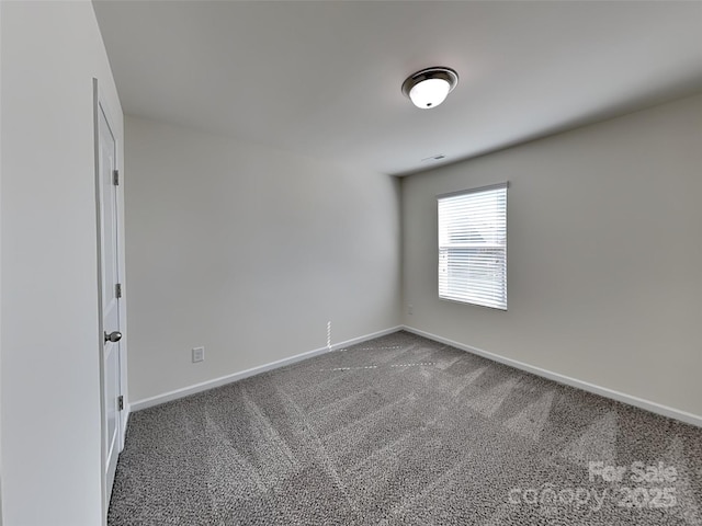 carpeted spare room featuring baseboards