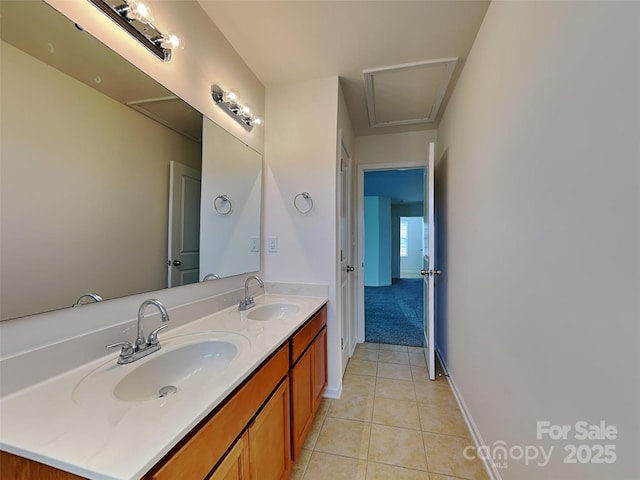 bathroom with tile patterned flooring, double vanity, baseboards, and a sink