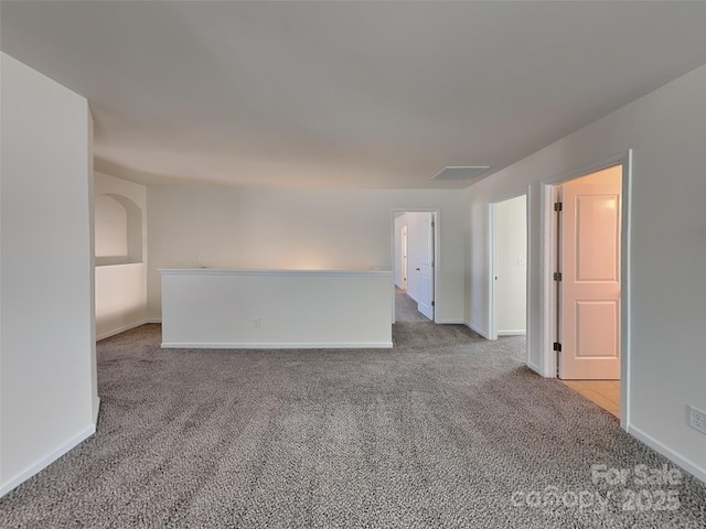 spare room featuring baseboards and carpet floors