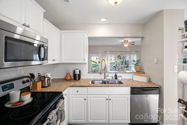 kitchen with a sink, decorative backsplash, white cabinetry, and stainless steel appliances