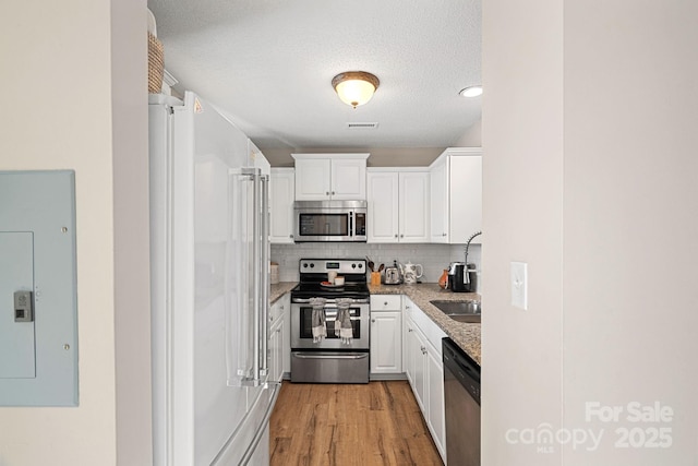 kitchen featuring white cabinets, light wood-style floors, visible vents, and stainless steel appliances