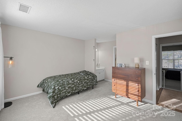 carpeted bedroom with visible vents, a textured ceiling, and baseboards