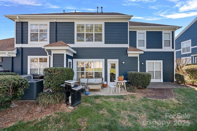 rear view of property with central air condition unit, a lawn, and a patio