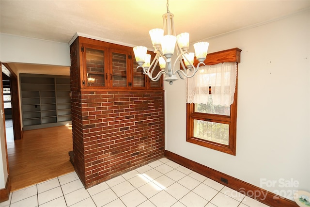 dining space with crown molding, light tile patterned floors, plenty of natural light, and a chandelier