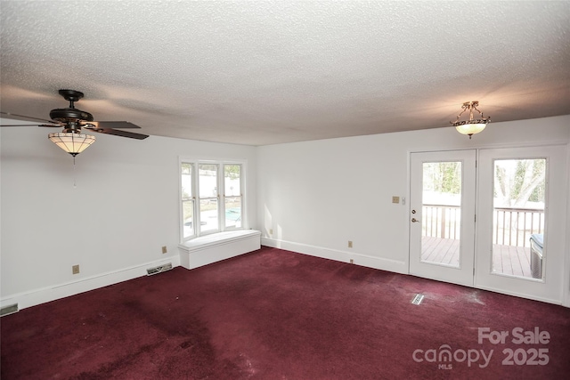 unfurnished room with visible vents, carpet, a healthy amount of sunlight, and a ceiling fan