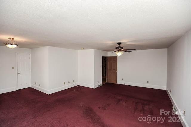 carpeted empty room featuring baseboards, a textured ceiling, and a ceiling fan