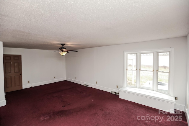 spare room with visible vents, radiator heating unit, ceiling fan, a textured ceiling, and dark carpet