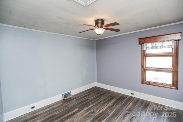 spare room with dark wood finished floors, baseboards, visible vents, and ornamental molding