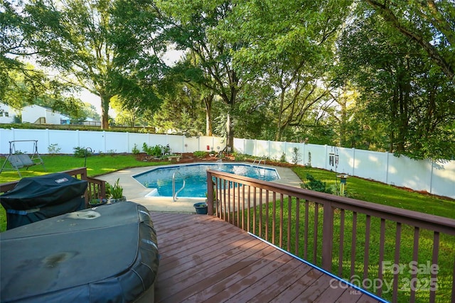 view of pool with area for grilling, a lawn, and a fenced backyard