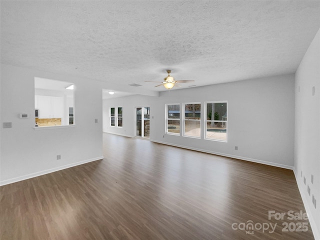 unfurnished living room featuring baseboards, a textured ceiling, dark wood finished floors, and a ceiling fan