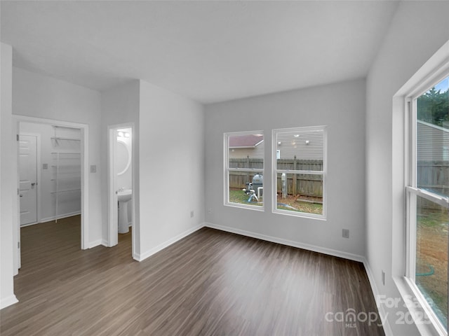 spare room featuring baseboards and wood finished floors