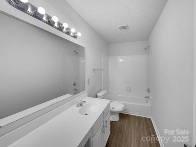 bathroom with toilet, a textured ceiling, wood finished floors, shower / bath combination, and vanity