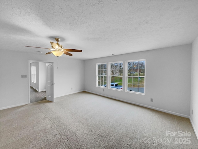 spare room with carpet, baseboards, and ceiling fan