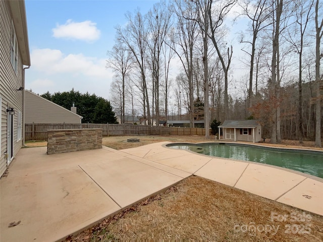 view of swimming pool featuring a fenced in pool, an outbuilding, a fenced backyard, and a patio area